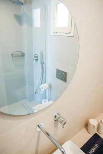 a bathroom with a shower and a mirror at Princess Hotel in Lassi
