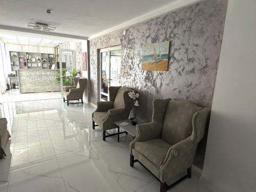 a living room with two chairs and a table at Hotel Decebal Eforie Nord in Eforie Nord