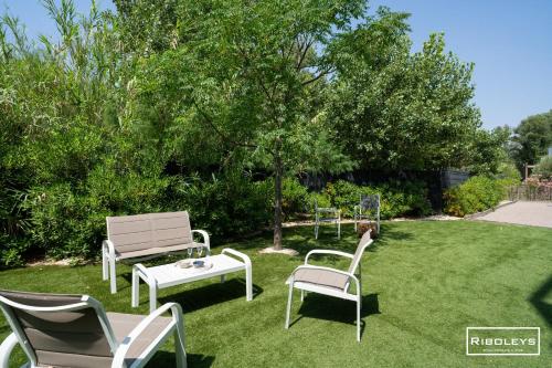 a group of chairs and a table on a lawn at Superbe T3 climatisé avec WIFI à 400m de la plage in Vias