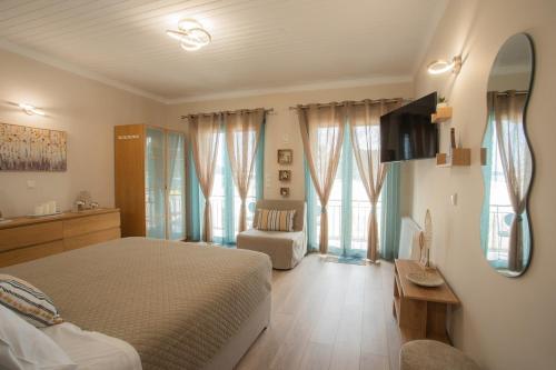 a bedroom with a bed and a chair and a mirror at Manolias Apartment Nydri Center in Nydri