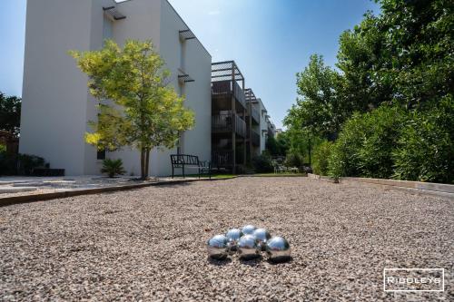 a group of balls sitting on top of a gravel road at Superbe T3 climatisé avec WIFI à 400m de la plage in Vias