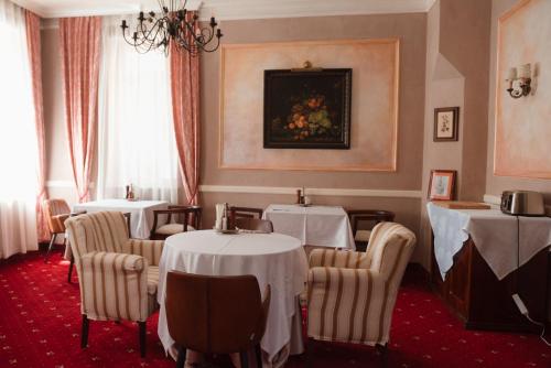 a dining room with tables and chairs with white table cloth at Hotel La Residenza in Timişoara