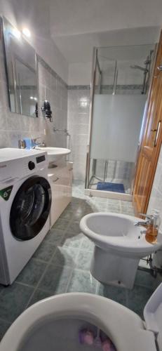 a bathroom with a toilet and a sink and a washing machine at Villa Rosmarino in Siniscola