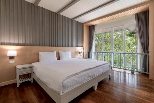 a bedroom with a large bed and a large window at Na Sook Wellness Resort in Ao Nam Mao