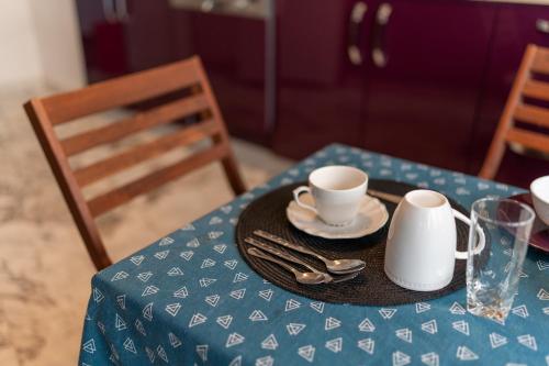a table with a blue table cloth with cups and saucers at Elegance in Télemly, View of Algiers Bay in LʼAgha
