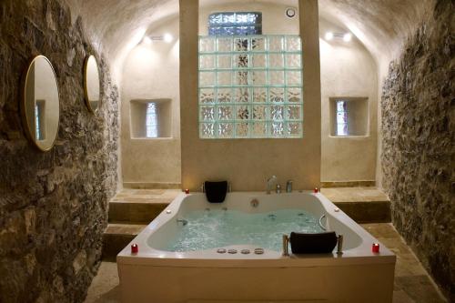 a large bath tub in a room with a window at Love Room du Château Fort - Jacuzzi & Insolite ! in Mercury