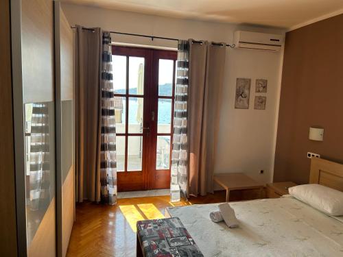 a bedroom with a bed and a large window at Rooms Perina Tisno in Tisno