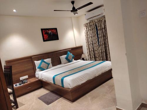 a bedroom with a bed with a wooden headboard at Hotel Chaitanya Executive in Māngvādi