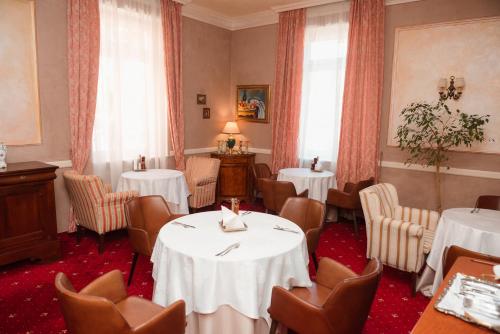 a dining room with two tables and chairs in a room at Hotel La Residenza in Timişoara