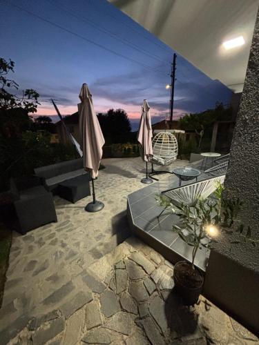 a patio with two umbrellas and a table with a plant at Edelweiss Villa Trpejca in Ohrid