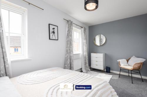 a white bedroom with a bed and a chair at Three Bedroom House By The Yuma Homes Short Lets & Serviced Accommodation In Ashford With Free Wifi & Free Parking in Kent