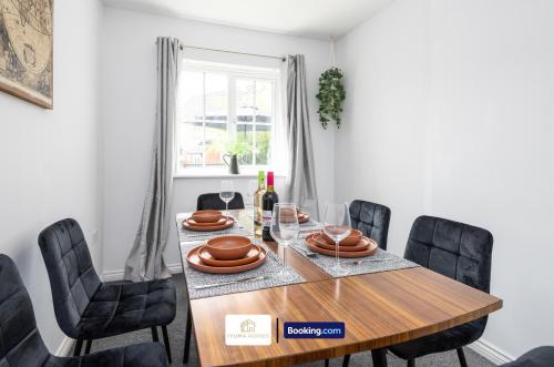 a dining room with a wooden table and black chairs at Three Bedroom House By The Yuma Homes Short Lets & Serviced Accommodation In Ashford With Free Wifi & Free Parking in Kent