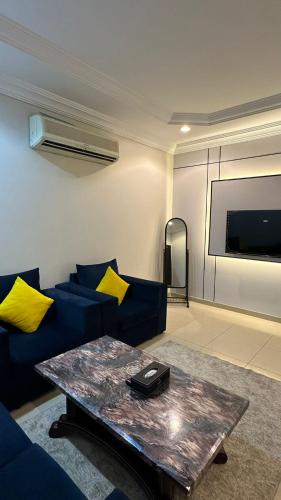a living room with a blue couch and a table at راحتي للشقق المخدومة in Taif