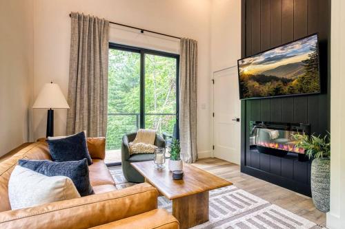 a living room with a couch and a fireplace at Peaceful Smoky Treehouse| Hot Tub • Hammock • Deck in Line Spring