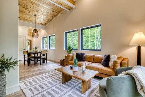 a living room with a couch and a table at Peaceful Smoky Treehouse| Hot Tub • Hammock • Deck in Line Spring
