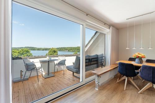 a living room with a large window and a table and chairs at Haus Dieksee Holm Dieksee-Idyll in Gremsmühlen