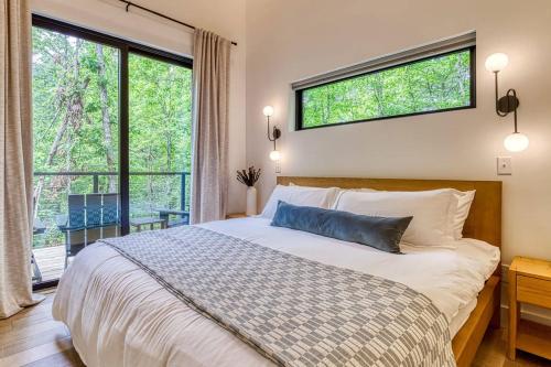 a bedroom with a bed and a large window at Peaceful Smoky Treehouse| Hot Tub • Hammock • Deck in Line Spring
