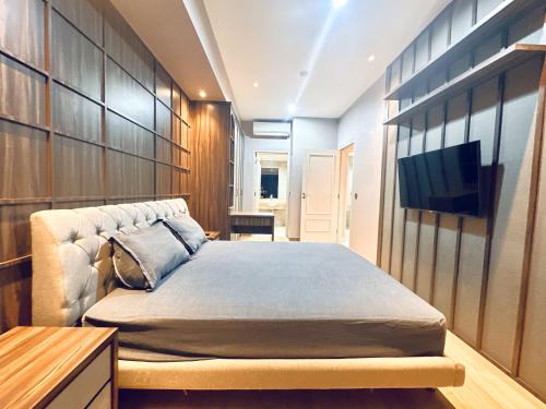 a bedroom with a bed and a flat screen tv at Vista at The Peak 2BR Apartment in Tunjungan Plaza 5 Surabaya by Le Ciel Hospitality in Surabaya