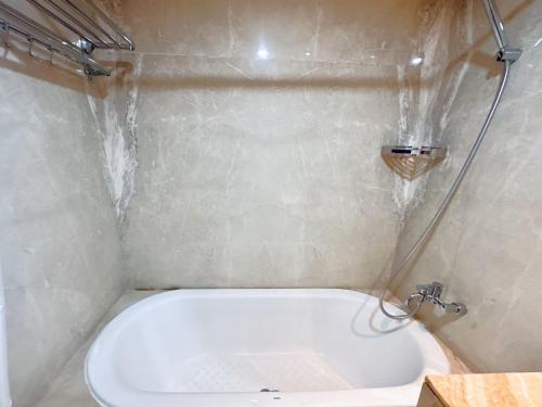 a small bathroom with a tub and a shower at Vista at The Peak 2BR Apartment in Tunjungan Plaza 5 Surabaya by Le Ciel Hospitality in Surabaya