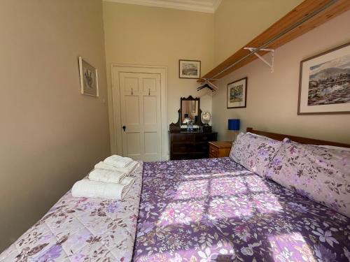 a bedroom with a purple bed with towels on it at Parteen A Lax, River House & Gardens in Limerick