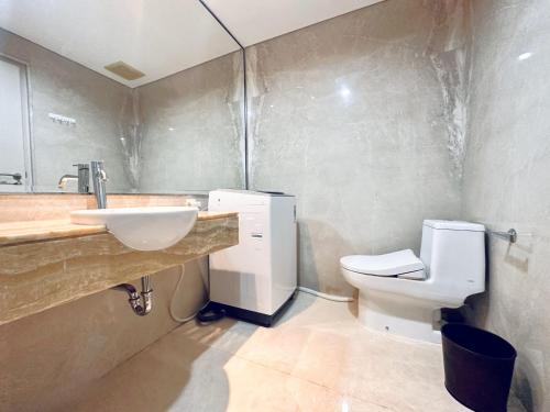 a bathroom with a sink and a toilet at Vista at The Peak 2BR Apartment in Tunjungan Plaza 5 Surabaya by Le Ciel Hospitality in Surabaya