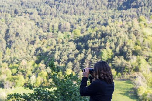 a woman taking a picture of a forest at Casa Rural Baró in Tornafort