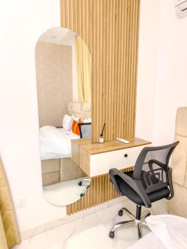a bedroom with a desk and a chair and a mirror at Stay Well Homes Comfortinn in Eregun