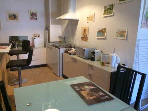 a kitchen with a table and a counter top at du coté de chez soi in Loupian