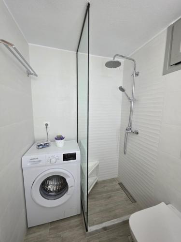 a bathroom with a washing machine and a shower at Elounda Alley in Elounda
