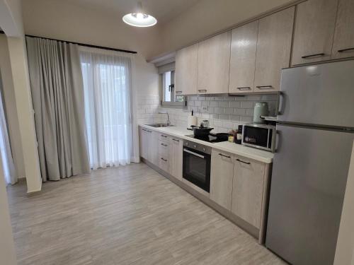 a kitchen with a stainless steel refrigerator and cabinets at Elounda Alley in Elounda