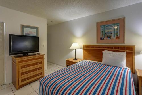 a bedroom with a bed and a flat screen tv at Richard's Motel Studios in Hollywood