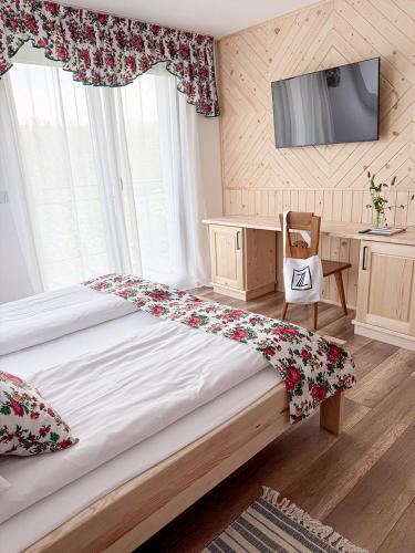 a bedroom with a large bed and a television at Zwijaczówka in Zakopane