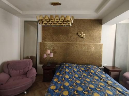 a bedroom with a bed and a chair at Baku Lake view apartment in Xirdalan