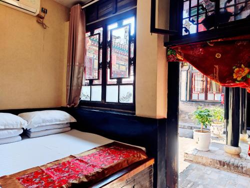 a bed in a room with a window at Pingyao Xiangshengyuan Guest House in Pingyao
