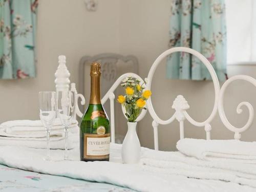 a bottle of champagne and a vase with flowers on a table at Wonderfully situated in the heart of Exmoor in Exford