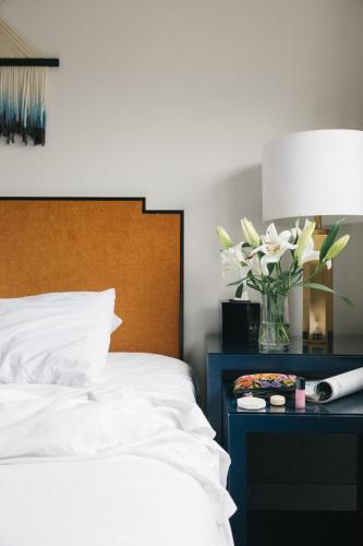 a bedroom with a bed and a vase of flowers on a table at Redford Hotel in New York