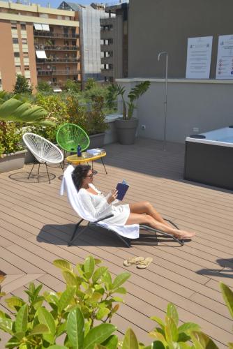 a woman laying in a chair reading a book at ELLEMENTS - Luxury Rooms in Brindisi