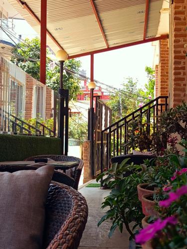 a patio with chairs and plants on a balcony at Deepjyoti Inn in Pashupatināth