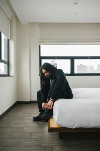 a woman kneeling on a bed in a room at Orchard Street Hotel in New York