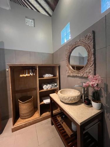 ウブドにあるBadra House Bougainvilleaの洗面台と鏡のあるバスルーム