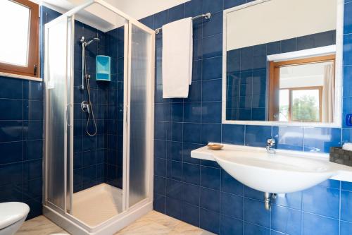 a blue tiled bathroom with a sink and a shower at Hotel San Giovanni in Polignano a Mare