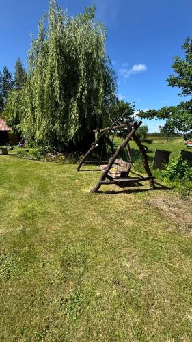 a piece of equipment in a field with a tree at Artystyczna sielanka 