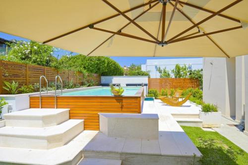 patio con ombrellone e piscina di Villa Rei M&M- sea view, swimming pool & Jacuzzi a Costa Rei
