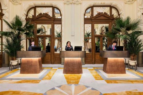 a group of people in a lobby with their laptops at NH Collection Prague Carlo IV in Prague