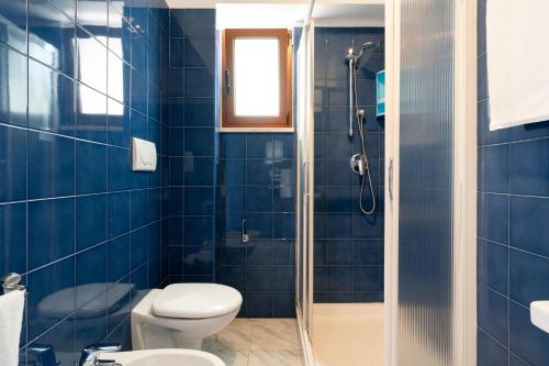 a blue bathroom with a toilet and a shower at Hotel San Giovanni in Polignano a Mare