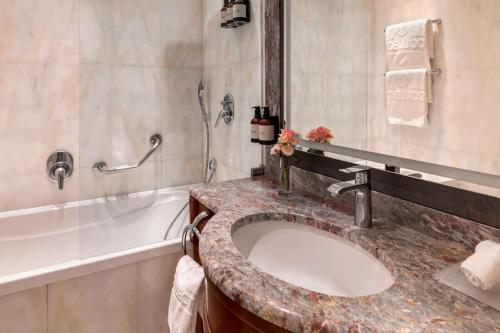 a bathroom with a sink and a bath tub at NH Collection Prague Carlo IV in Prague