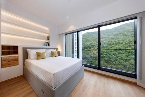 a bedroom with a bed and a large window at Shama Hub Metro South Hong Kong in Hong Kong