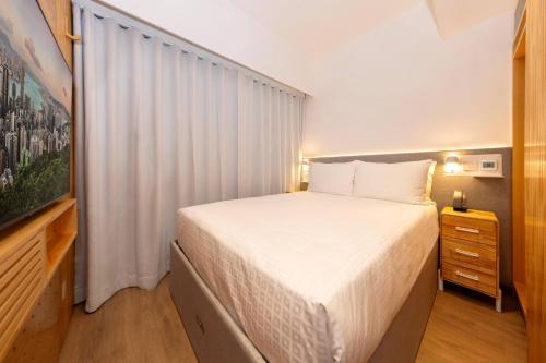 a small bedroom with a bed and a television at Shama Hub Metro South Hong Kong in Hong Kong