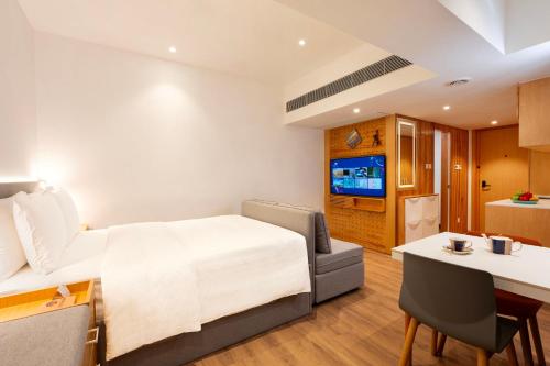 a hotel room with a bed and a kitchen at Shama Hub Metro South Hong Kong in Hong Kong