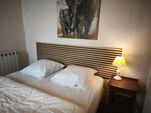 ヴィシーにあるLe Tour - Hypercentre - Opéra 150 m - Bord d'Allierの木製のヘッドボードが付いた白いベッドのある寝室